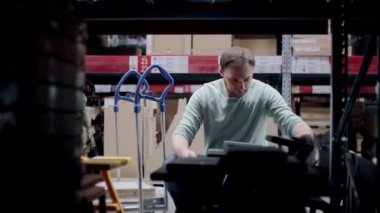 Bir adam plastik sandalyeleri alıp depodaki tramvaya koyuyor. raflardan görüntüle