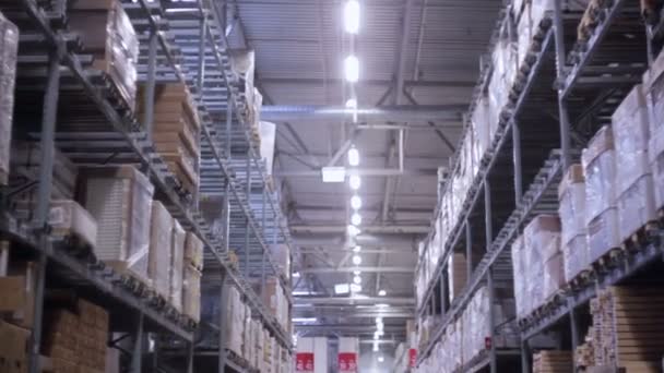 Paletas con cajas de cartón y materiales en estantes en un almacén, lento mo, dolly shoot — Vídeos de Stock