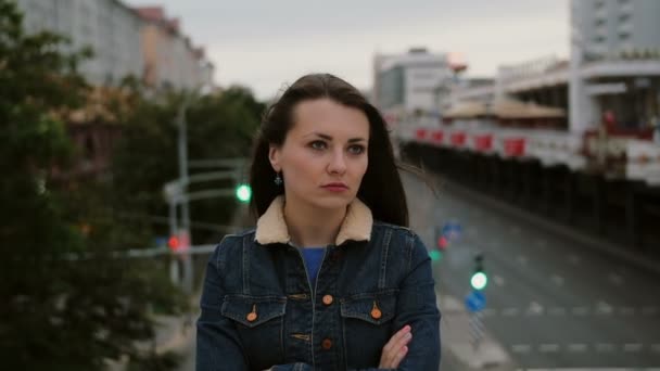 Раздраженная девушка, стоящая на мосту, выражает свое недовольство, разочарование негативными эмоциями и смотрит в камеру. 4K — стоковое видео