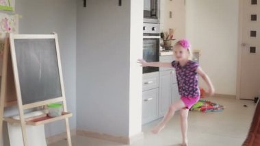 young daughter tossing a big gym balloon to her dad in the living room.
