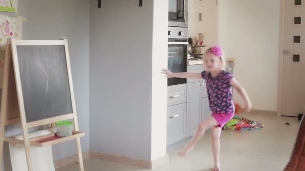 Маленькая дочь бросает большой спортивный шарик своему отцу в гостиную . — стоковое видео