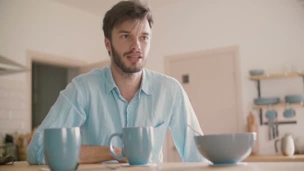 Jeune homme ayant une conversation à la table de la cuisine. Mouvement lent — Video