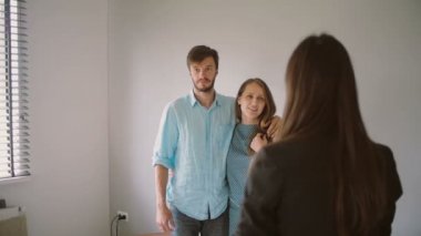 Bir çift siyah ceketli bir kadınla konuşurken beyaz bir odanın dış bakıyor. Yavaş mo, Steadicam atış
