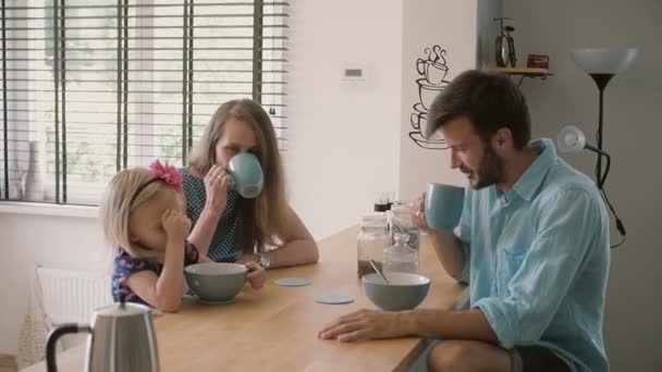 Die junge glückliche Familie frühstückt morgens friedlich. Zeitlupe, Steadicam-Aufnahme — Stockvideo
