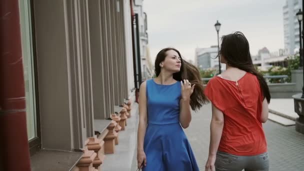 Young girls friends with shopping bags discussing new collection by the shopping window. slow mo — Stock videók