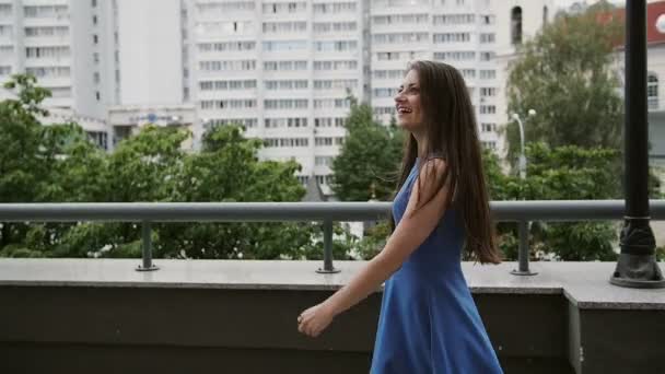 Vento soffia lunghi capelli scuri felice bella giovane donna a piedi per strada, vista posteriore, lento mo stedicam shot — Video Stock