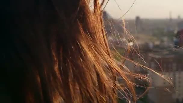 Wind blows long dark hair. girl standing on the roof with his head down. close up. Slow motion — ストック動画