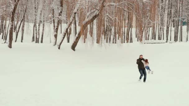 Młoda rodzina bawi się i bawi na śniegu — Wideo stockowe