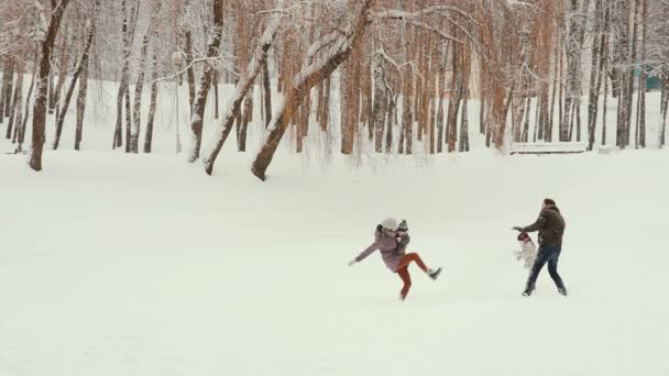 Ung familj leker och har roligt i snön — Stockvideo