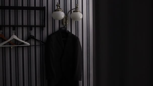 Stilvoller Geschäftsmann zieht im strengen Interieur seine Jacke vom Kleiderbügel — Stockvideo