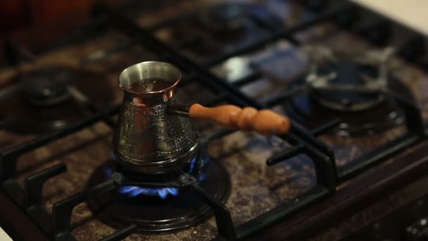 Blick auf Kaffee in einer Kaffeekanne mit langem Griff, der sich auf Feuer vorbereitet. — Stockvideo