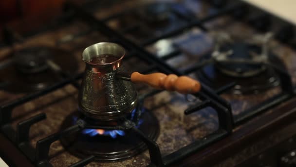 Une vue du café dans une cafetière avec une longue poignée préparant sur le feu . — Video