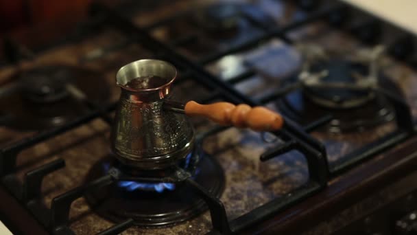 Une vue sur le café dans une cafetière préparant sur le feu. Les mains d'un homme le remuant avec une cuillère à la fin . — Video