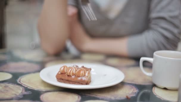 Un trozo de pastel cortado con un tenedor por una chica . — Vídeo de stock
