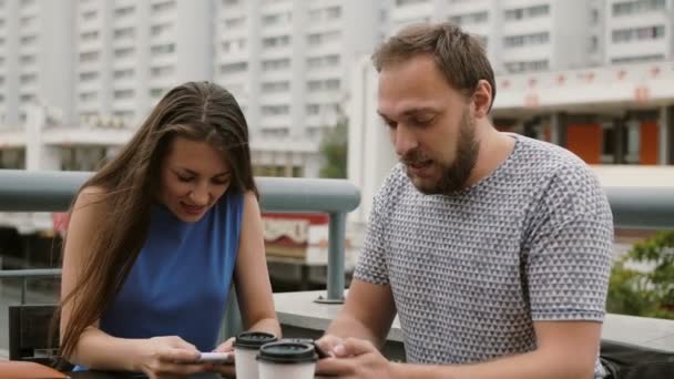 Beautiful young couple playing as a team game online on their smartphones. they win, celebrate the victory, give five 4K — Stock Video