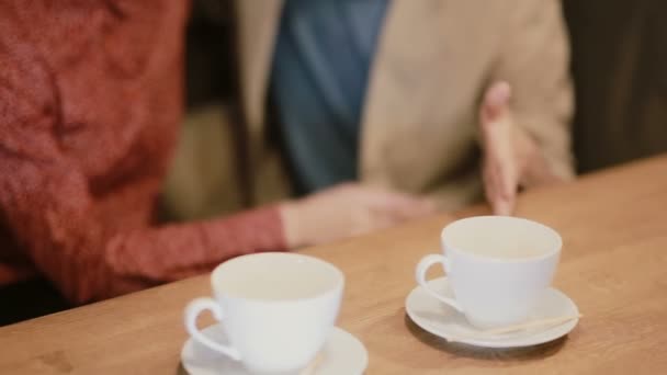 Una vista di tazze di caffè vuote sul tavolo e una coppia che si tiene per mano . — Video Stock