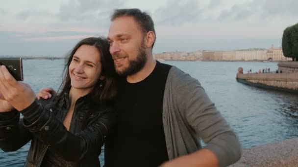 Beautiful young couple taking selfie on the background of river and the city. St. Petersburg. 4K — Stock Video