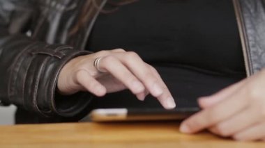 Kız eller close-up bir tablet sörf modern kafede oturan internet kullanır..