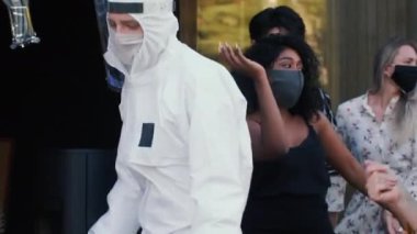 CoVID-19 tarzı eğlenceli partilerde güvenlik maskeleri ve kostümleriyle dans eden mutlu çok ırklı genç arkadaşlar grubu..