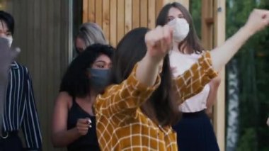 COVID-19 'dan sonra normal hayata dön. Mutlu çoklu etnik arkadaşlar, eğlenceli bir partide tıbbi güvenlik maskeleriyle dans ediyorlar..