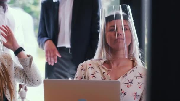 Захист від COVID-19 як новий спосіб життя. Портрет молодої щасливої блондинки-ген-бізнесу в щиті обличчя в офісі . — стокове відео