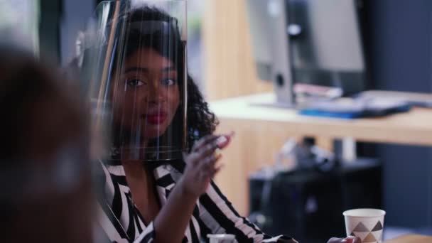 Detailní záběr šťastný mladý úspěšný černošky business žena v COVID-19 tvář štít úsměvy zvedá ruku na setkání kanceláře. — Stock video