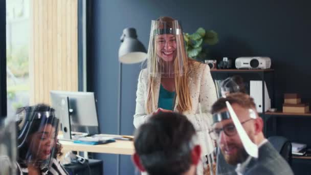 Hermosa mujer de negocios rubia feliz CEO sonríe líder reunión de equipo en la oficina moderna, todos llevan escudos faciales COVID-19. — Vídeos de Stock