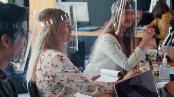 Junge glückliche attraktive Businesscoach spricht bei multiethnischen Büro-Team-Treffen, alle in COVID-19 Gesichtsschildern. — Stockvideo