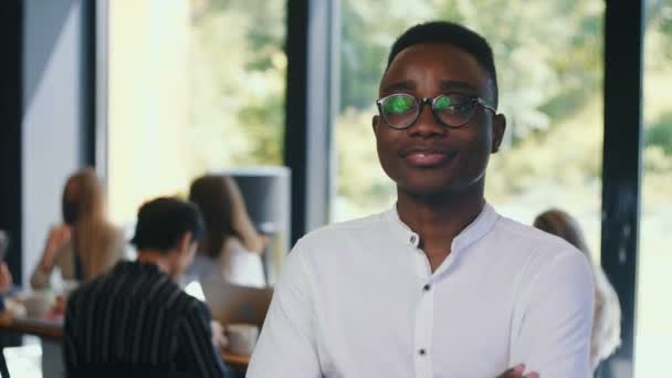 Retrato de feliz joven exitoso empresario africano sonriendo a la cámara, mirando en serio en la oficina moderna cámara lenta. — Vídeos de Stock