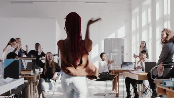 RED EPIC Back view feliz mujer de negocios africana emocionada bailando en la fiesta de celebración de la oficina entre colegas cámara lenta — Vídeo de stock