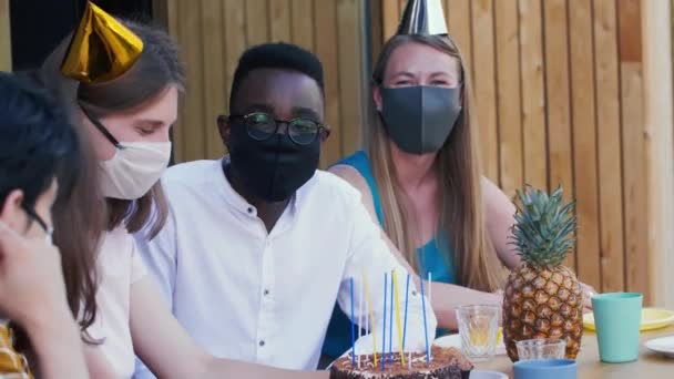 Geburtstagsfeier nach COVID-19. Junge multiethnische Freunde teilen Spaß beim Binden von Zeit mit medizinischen Gesichtsmasken. — Stockvideo