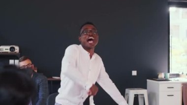 Mutlu genç Afrikalı iş adamı COVID-19 maskesini çıkardı ve ofis ekibi toplantısında konfeti altında normal bir hayatı kutladı..