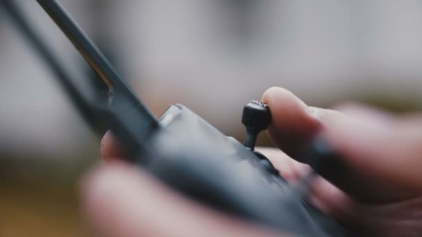 Ultra close-up, mannelijke handvinger duwen op afstandsbediening joystick, besturen van drone vliegtuigen als een hobby buiten. — Stockvideo