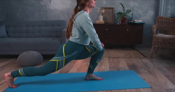 Jonge sportieve aantrekkelijke blonde vrouw doen yoga stretching oefening workout thuis gezond te houden op quarantaine. — Stockvideo