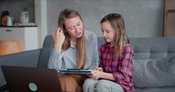 Utbildning i självisoleringsperiod. Glad vacker ung kaukasisk mor hjälpa tonårsdotter studera på karantän. — Stockvideo