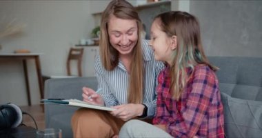 Mutlu, genç, beyaz bir anne, sevimli, genç kızına evde karantina öğrenmesi için yardım ediyor..