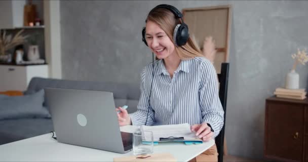 Εργασία από το σπίτι σε αυτο-απομόνωση. Ευτυχισμένη νεαρή χαμογελαστή ξανθιά επιχειρηματίας που εργάζονται σε απευθείας σύνδεση χρησιμοποιώντας φορητό υπολογιστή βιντεοκλήση. — Αρχείο Βίντεο