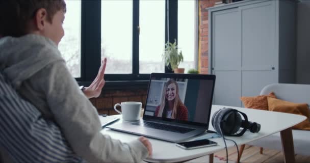 Concetto di videoconferenza. Eccitato giovane donna bionda sorride dallo schermo del computer portatile come amico con onda bambino a lei. — Video Stock