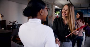 Çok ırklı bir iş yerinde iş görüşmesi. Genç ve güzel Afrikalı kadın çatı katında ağır çekimde hoş karşılandı.