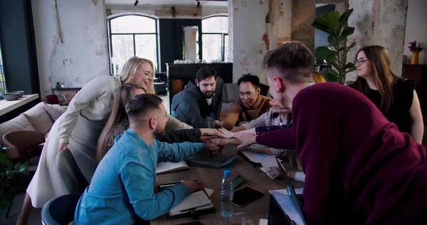 Feliz equipo multiétnico de profesionales de negocios poner las manos juntas y aplaudir en la oficina loft reunión de cámara lenta. — Foto de Stock