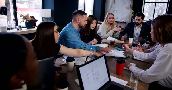 Concepto de lugar de trabajo saludable. Joven empresario confiado instruyendo a equipo multiétnico en reunión de negocios cámara lenta. — Foto de Stock