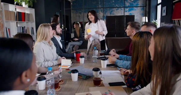Gente de negocios multiétnicos aplauden a la exitosa morena de mediana edad feliz entrenador femenino hablando en la reunión del equipo de oficina. — Foto de Stock