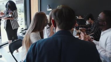 Coronavirus 'tan sonra ofis güvenlik önlemleriyle çalışır. Çok ırklı iş adamları birlikte çalışır, birlikte çalışırken maske takarlar..