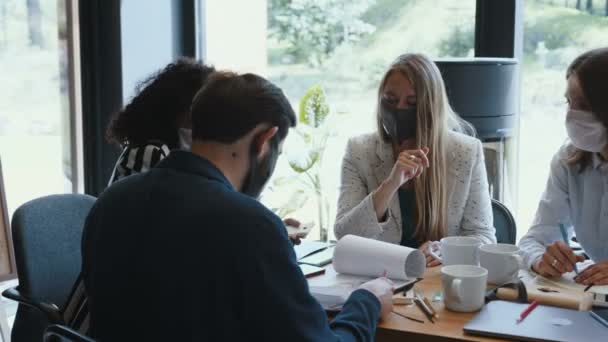 Masker als nieuw normaal op de werkplek. Gelukkige diverse zakenmensen werken samen op kantoor tafel vergadering na lockdown — Stockvideo