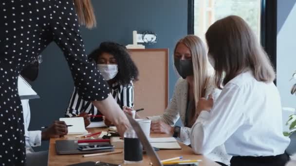 Reunião de negócios criativa após encerramento. Parceiros multiétnicos felizes consultando clientes em escritório leve em máscaras faciais. — Vídeo de Stock