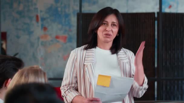 Portret van mooie gelukkige middelbare leeftijd Kaukasische baas zakenvrouw spreken op multi-etnische moderne licht kantoor vergadering. — Stockvideo
