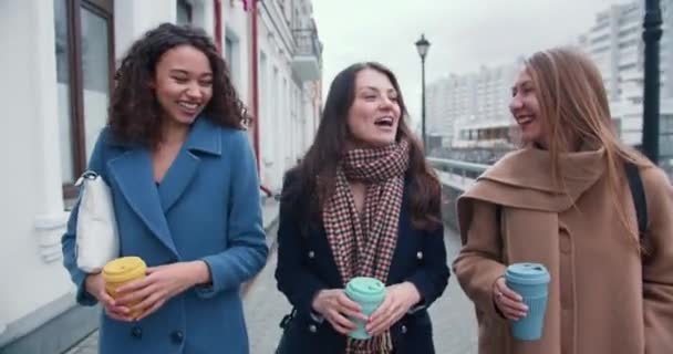 3.三位年轻貌美、事业有成的多民族女性朋友在城市街道边聊天边喝咖啡. — 图库视频影像