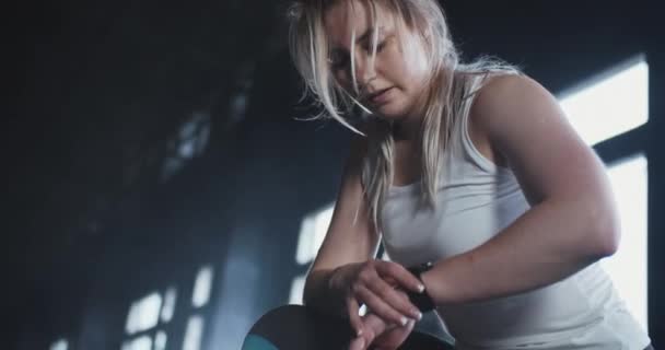 원문 기사보기 미국의 한 젊고 아름다운 여자 운동 선수가 격렬 한 운동을 한 후 피곤 한 스마트 시계 건강 앱을 사용하여 맥박을 체크하는 모습. — 비디오