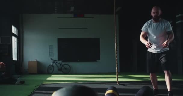 젊고 아름다운 운동 선수인 금발 여자 프로 남자 코치와 현대 체육관에서 크로스볼 잡기 운동을 하고 있는 모습. — 비디오