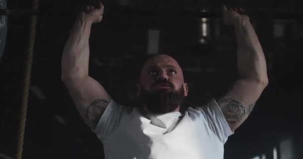 Entraînement d'haltérophilie professionnel. Gros plan jeune homme barbu caucasien chauve et fort soulève barbell dans une grande salle de gym moderne. — Video